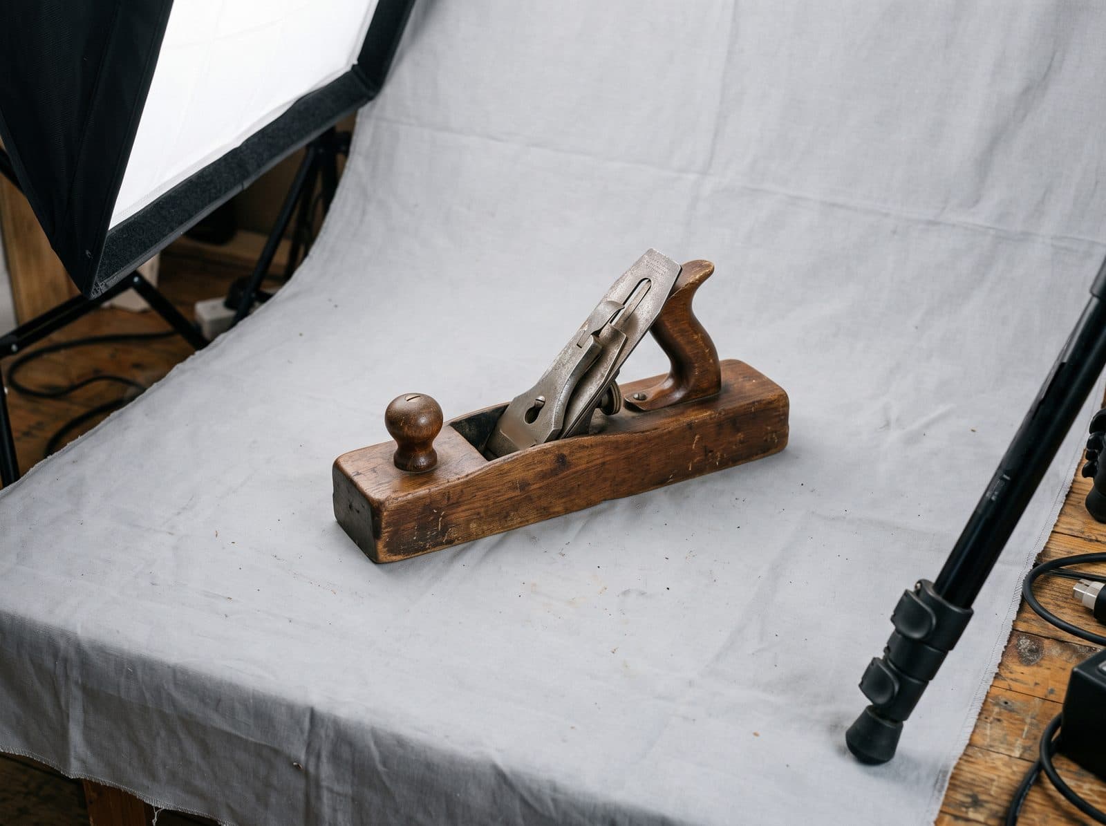 Studioaufbau mit Softbox und grauem Hintergrundtuch, darauf ein hölzerner Handhobel als Beispielprodukt